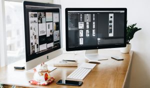 A well-organized design workspace with dual monitors and design software on display.